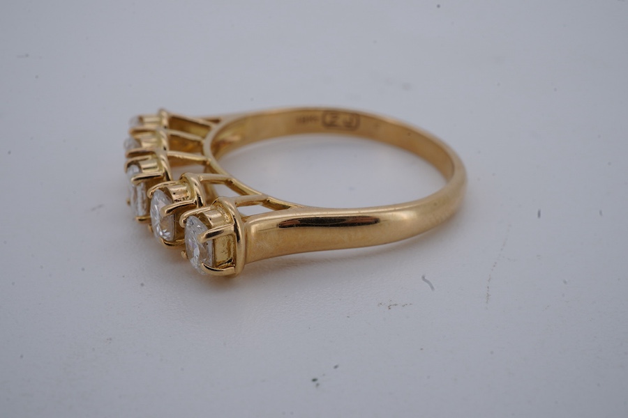 A five-stone diamond ring, claw-set with five oval diamonds totalling approximately 0.40 carats, mounted in gold, size M1/2, stamped 18K, gross weight approximately 3.5 grams